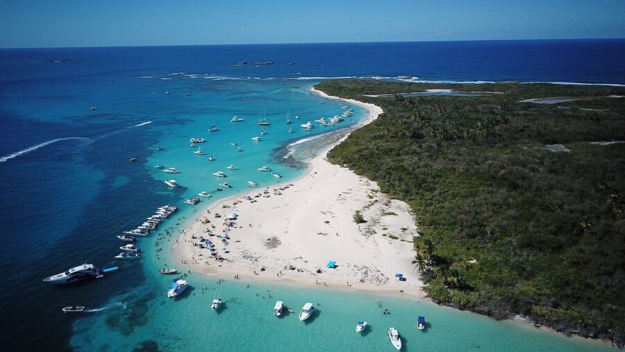 Aerial view of tropical Icacos Island sandbar with turquoise water, boats, and beach umbrellas.