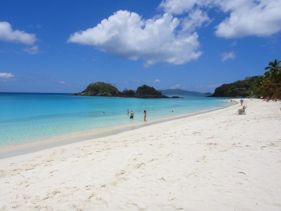 Trunk Bay Beach, St. John, U.S. Virgin Islands, featuring a sandy shore, clear water, and swimmers enjoying the sun.