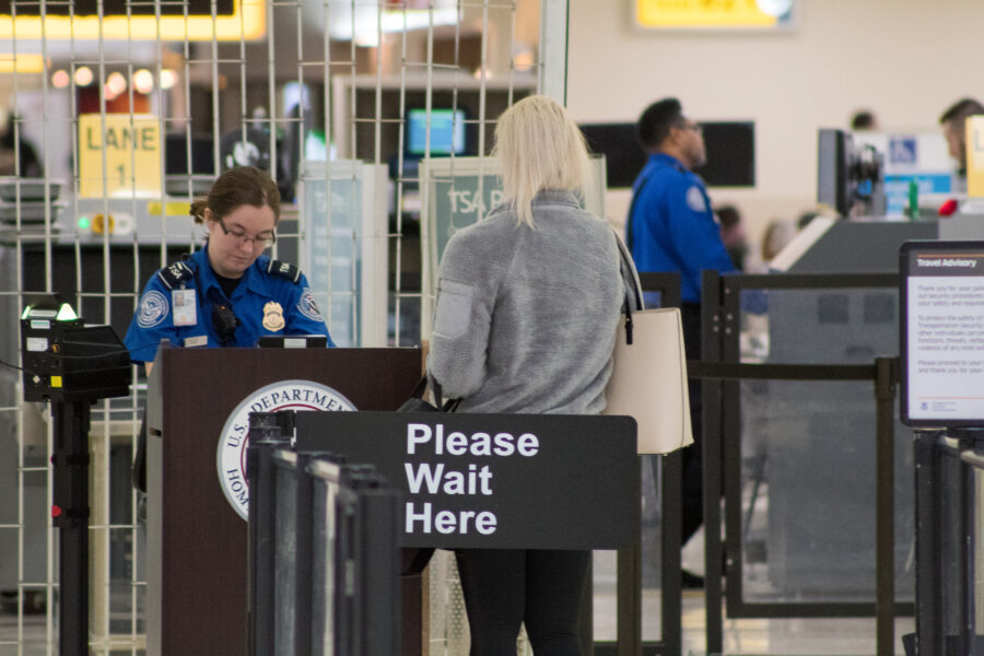 Travelers waiting in the TSA PreCheck line at an airport, preparing for security screening with minimal delays.
