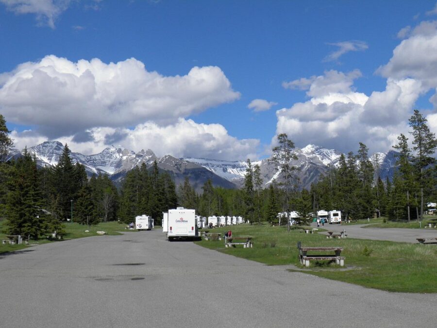 Tunnel Mountain Village II Campground features a spacious parking lot with multiple RVs parked throughout.