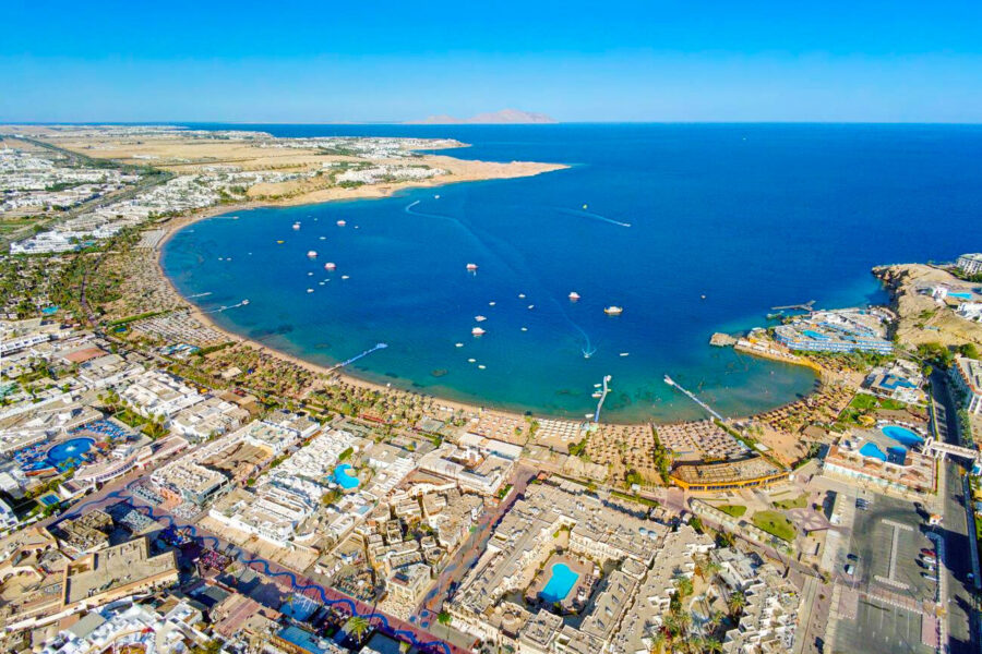 Aerial view of Naama Bay Sharm El Sheikh resort hotels, turquoise Red Sea beach and desert.