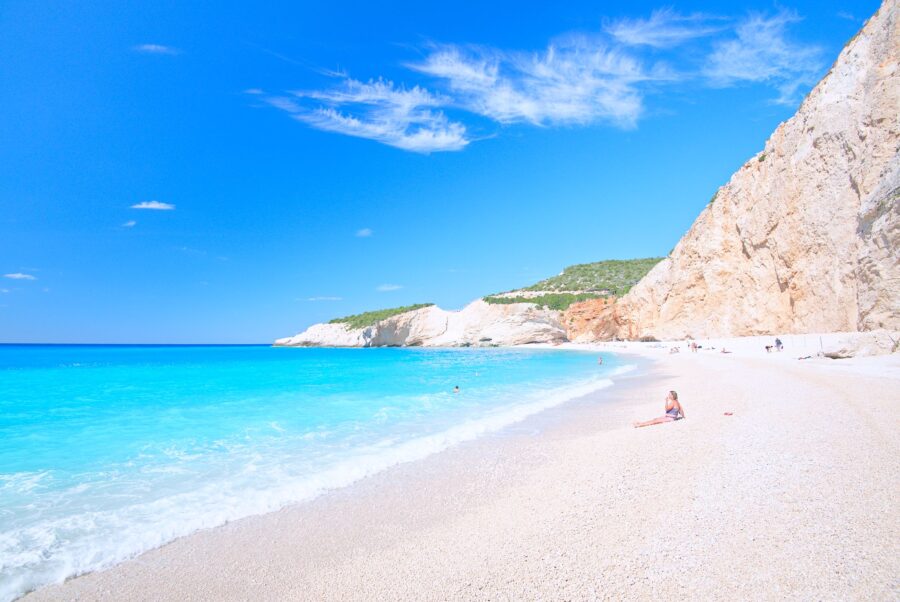 Pristine beach with turquoise waters, cliffs, and sunbathers at Porto Katsiki.