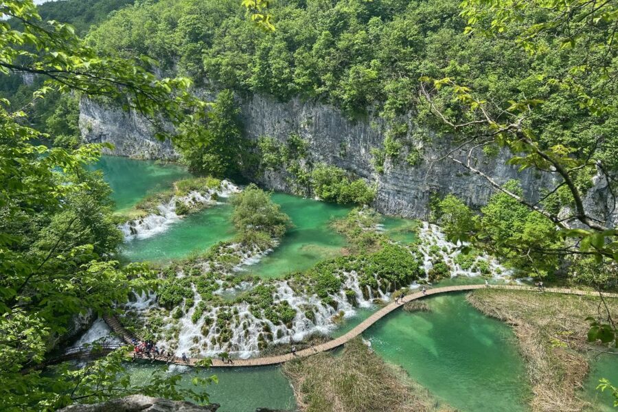 Panoramic view of lush greenery, turquoise lakes, and winding pathways in Plitvice Lakes National Park.
