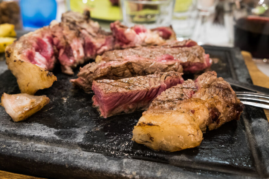 Perfectly cooked T-bone steak, "bistecca alla Fiorentina," highlighting the flavors of traditional Tuscan cuisine