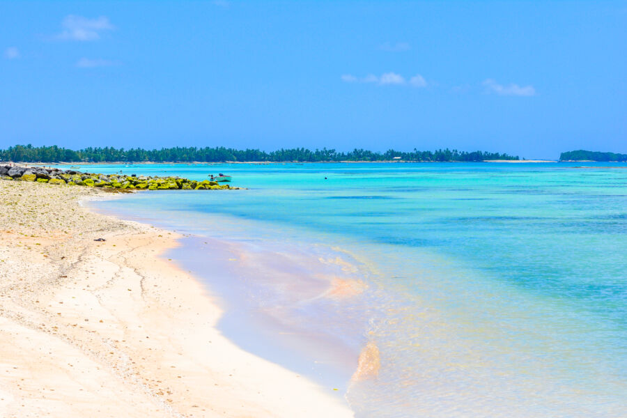 Tuvalu's idyllic beach showcases a vibrant blue lagoon, nestled within the peaceful expanse of the Pacific Ocean