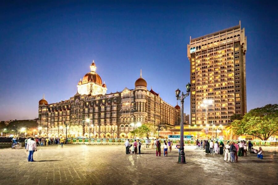 Taj Mahal Palace Hotel at dusk, Mumbai skyline, blending historic Indo-Saracenic architecture with modernity.