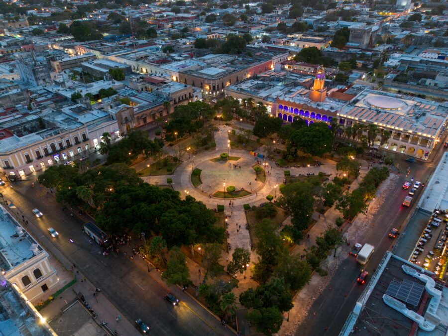 Aerial view of vibrant urban square merging colonial and modern architecture at twilight.