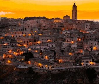 Panoramic view of historic town at twilight with stunning architecture and vibrant sunset sky.