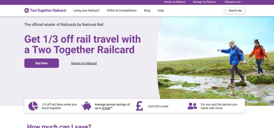 Two people hike across a grassy landscape with rocks. Text promotes "1/3 off rail travel with a Two Together Railcard." Tone is adventurous and inviting.
