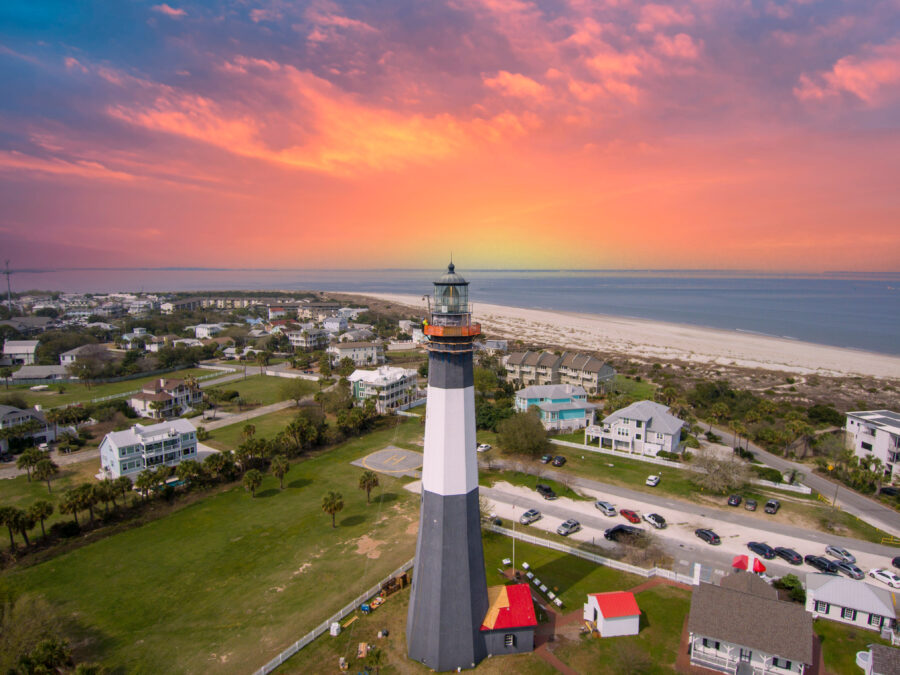 Stunning aerial shot of Tybee Island Beach during sunset, highlighting the lush spring scenery and the lighthouse