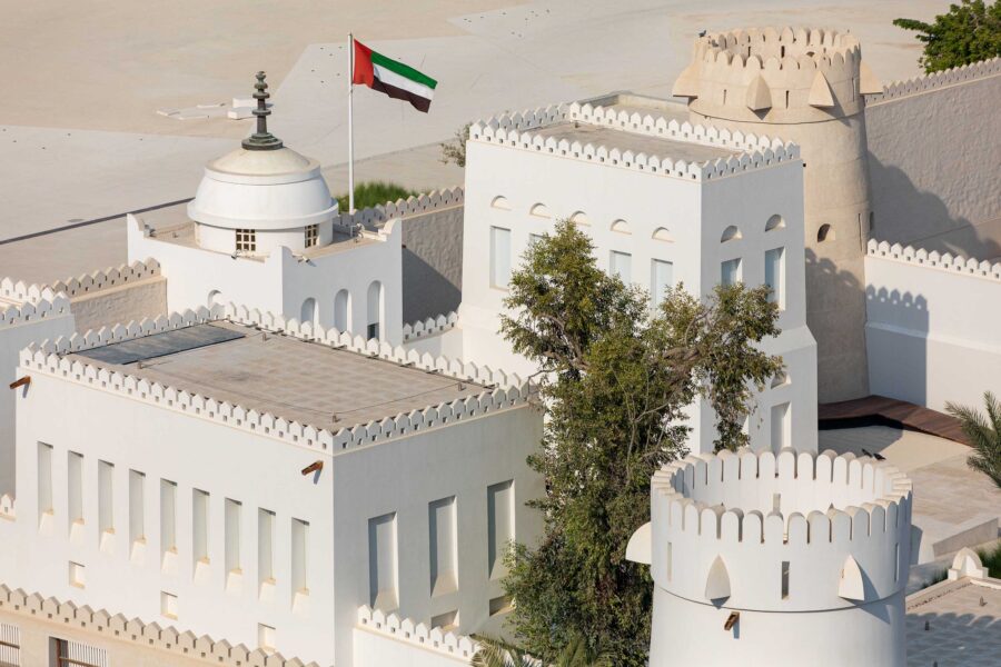 Qasr al Hosn Abu Dhabi white fortress with UAE flag, historic desert fort architecture.