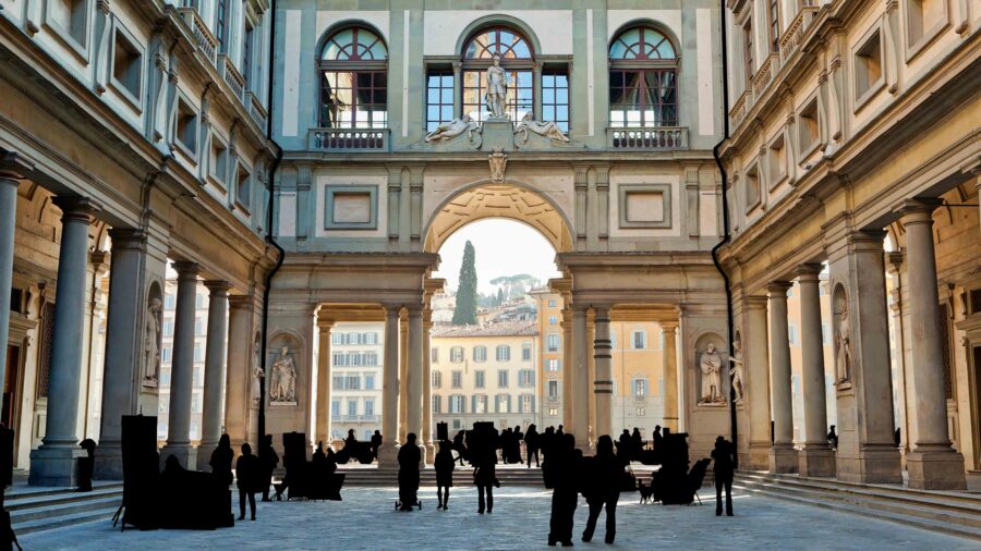 Renaissance architecture with grand archways and human silhouettes at Uffizi Gallery, Florence.