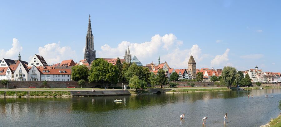 Ulm Panorama showcases a river, a bridge, and a church in the background, highlighting the serene landscape.
