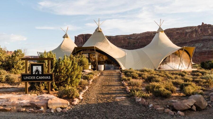Desert scene featuring a tipi tent at Under Canvas Moab, highlighting outdoor accommodation in a natural setting.