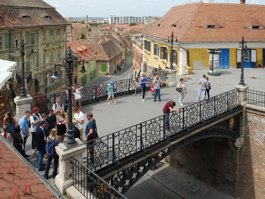 Bustling urban bridge scene with historic architecture, vibrant colors, and diverse people.