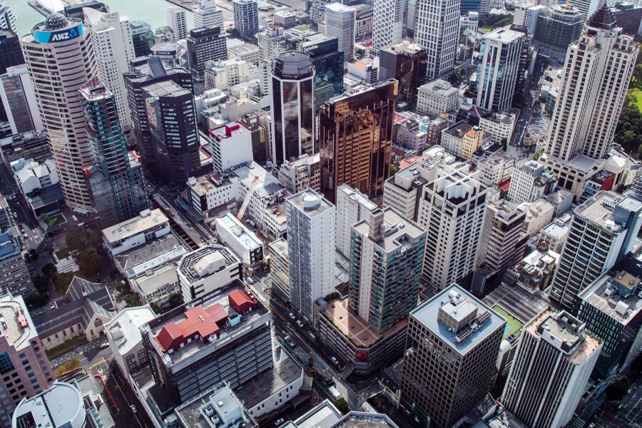 Aerial view of a vibrant modern city skyline with high-rise buildings and a shimmering waterfront.