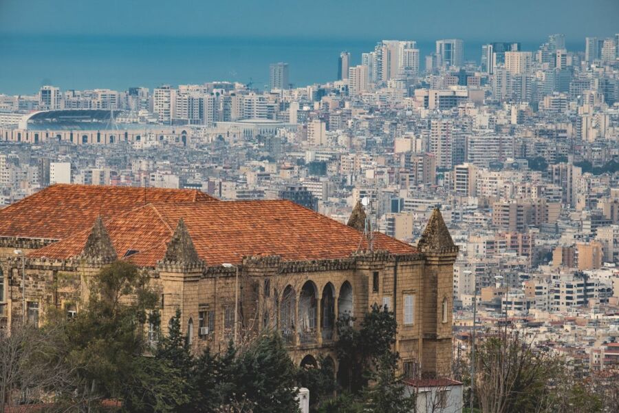 Historic architecture contrasts with modern skyline and Mediterranean Sea.