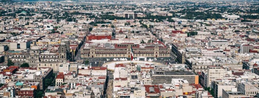 Aerial view of vibrant city landscape with diverse architecture and scenic natural backdrop.