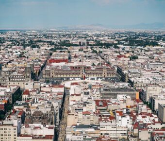 Aerial view of vibrant city landscape with diverse architecture and scenic natural backdrop.