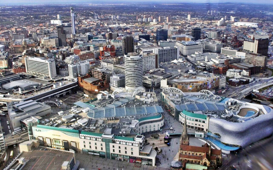 Birmingham cityscape with modern and historic architecture, vibrant shopping complex, and urban greenery.