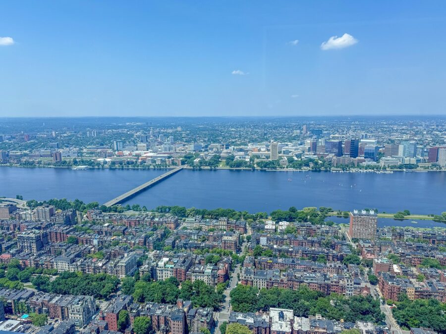 Aerial view of Boston cityscape with Charles River, historic architecture, and vibrant urban greenery.