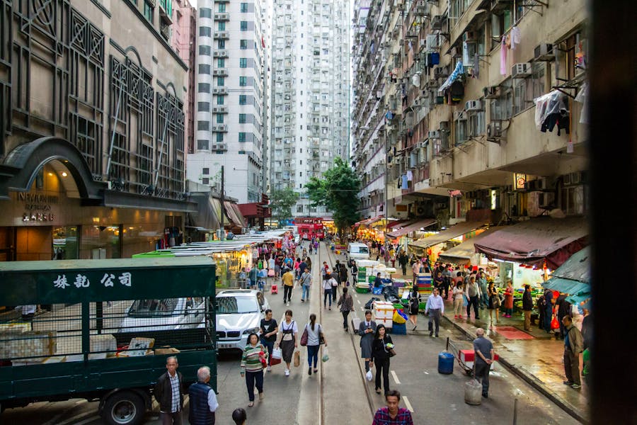 Bustling Hong Kong street market scene with diverse architecture and vibrant community interactions.