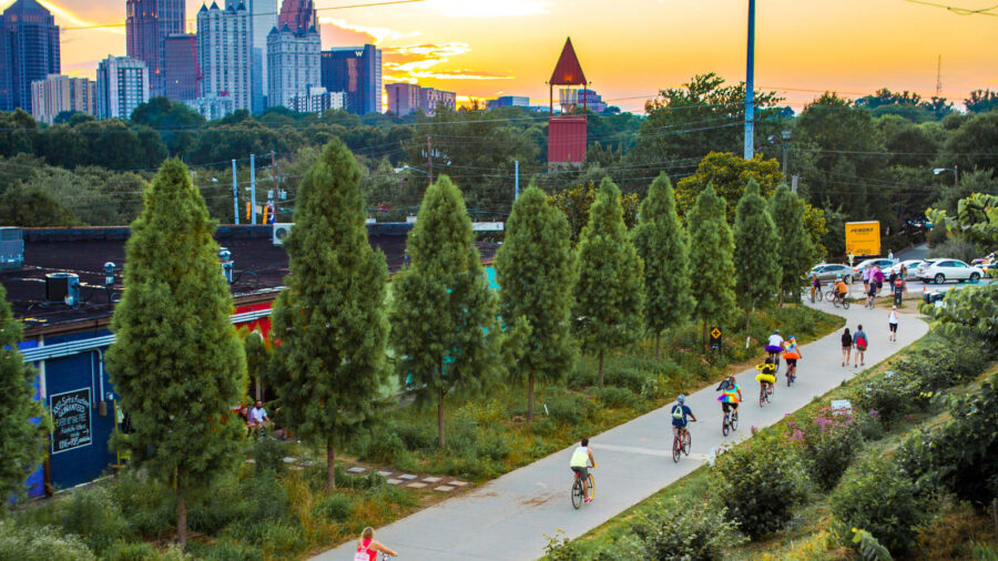 Sunset urban park scene with skyline, cyclists, and lush greenery in harmonious balance.