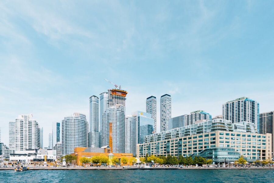 Modern city skyline with skyscrapers, waterfront, construction cranes, and vibrant urban lifestyle.