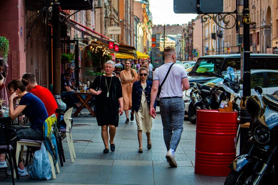 Bustling European street with diverse fashion, outdoor dining, and vibrant city life.