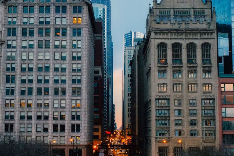 Twilight urban street with modern and classic architecture, bustling city life.