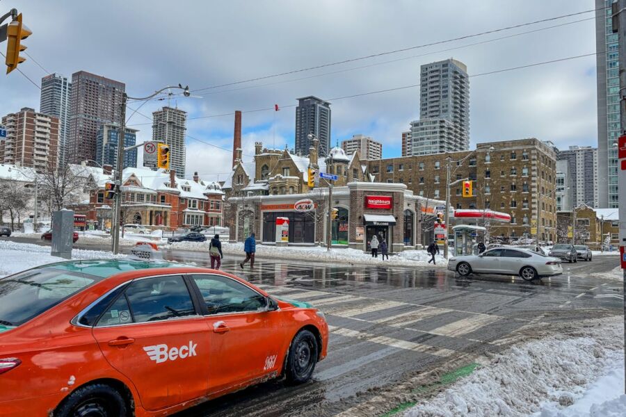 Winter urban scene with Beck taxi, snow-covered streets, pedestrians, and architectural contrast.