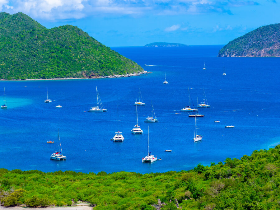 Catamarans anchored in Watermelon Bay, U.S. Virgin Islands, with vibrant sails reflecting the tropical scenery
