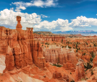 Scenic view of Bryce Canyon National Park, showcasing its iconic hoodoos and vibrant red rock formations under a clear sky.