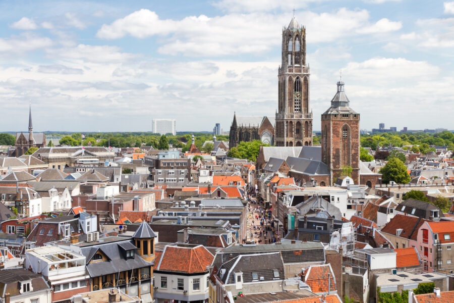Cityscape of Utrecht, Netherlands, featuring historic buildings, canals, and a clear blue sky