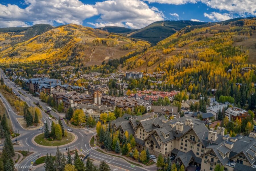 Aerial view of downtown Vail, Colorado, showcasing vibrant autumn foliage and charming mountain architecture