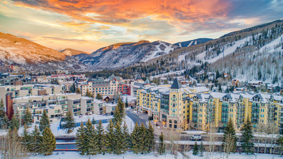Aerial panoramic view of Vail, Colorado, showcasing a snow-covered village skyline and surrounding mountains