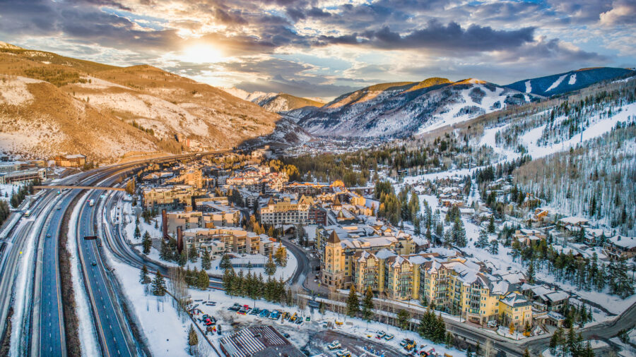 Aerial view of Vail, Colorado at sunrise, showcasing the mountains and vibrant colors of the sky