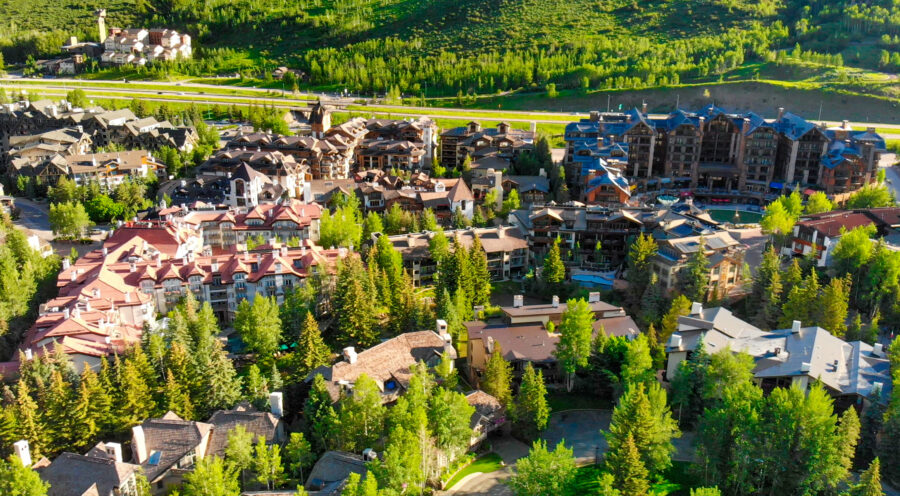 Summer aerial view of Vail, Colorado, highlighting vibrant greenery and the picturesque layout of the town below