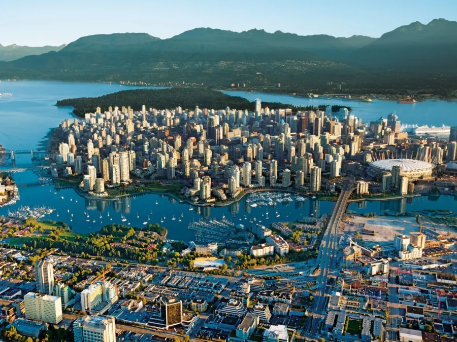 Aerial view of Vancouver: city skyline, mountains, water, boats, stadium, nature.