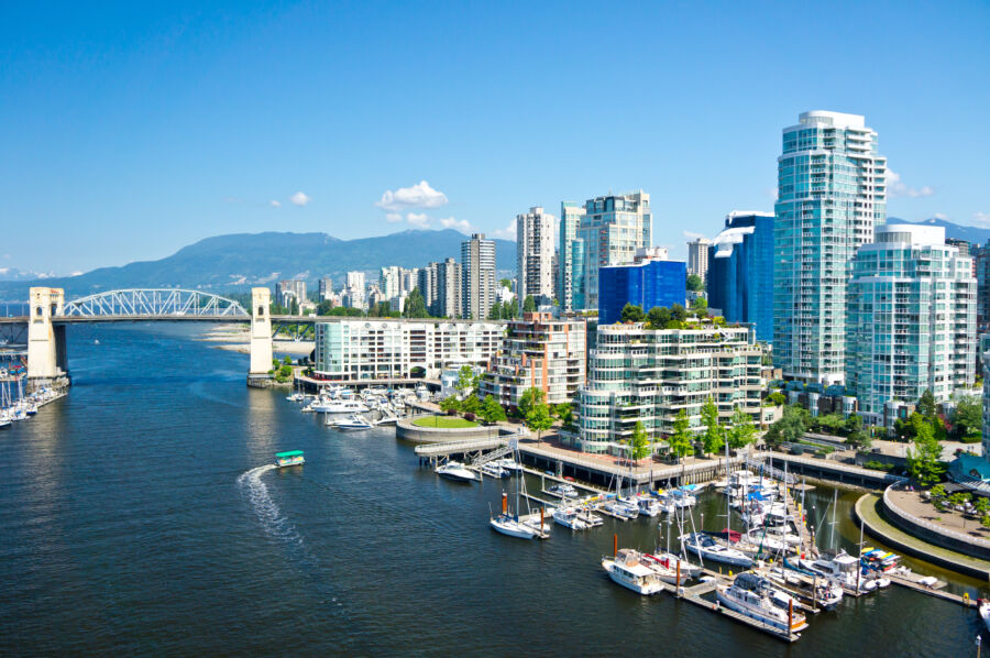 Scenic view of Vancouver, British Columbia, showcasing the skyline against a backdrop of mountains and water.
