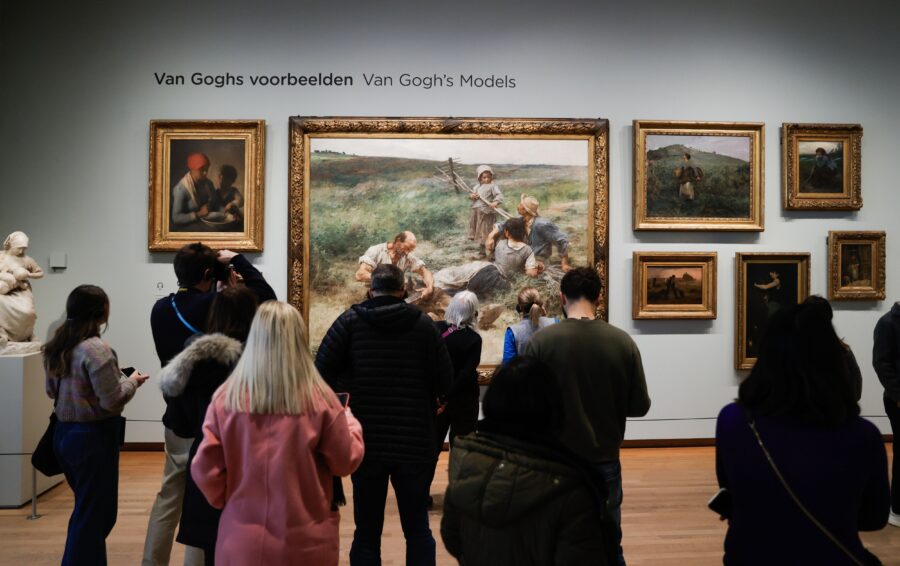 Art gallery visitors admiring Van Goghs Models artworks, featuring paintings and sculpture display.