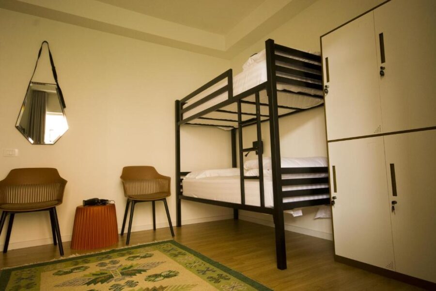 Bunk bed with a chair and table in a room at Vanilla Sky Boutique Hostel, Tirana.