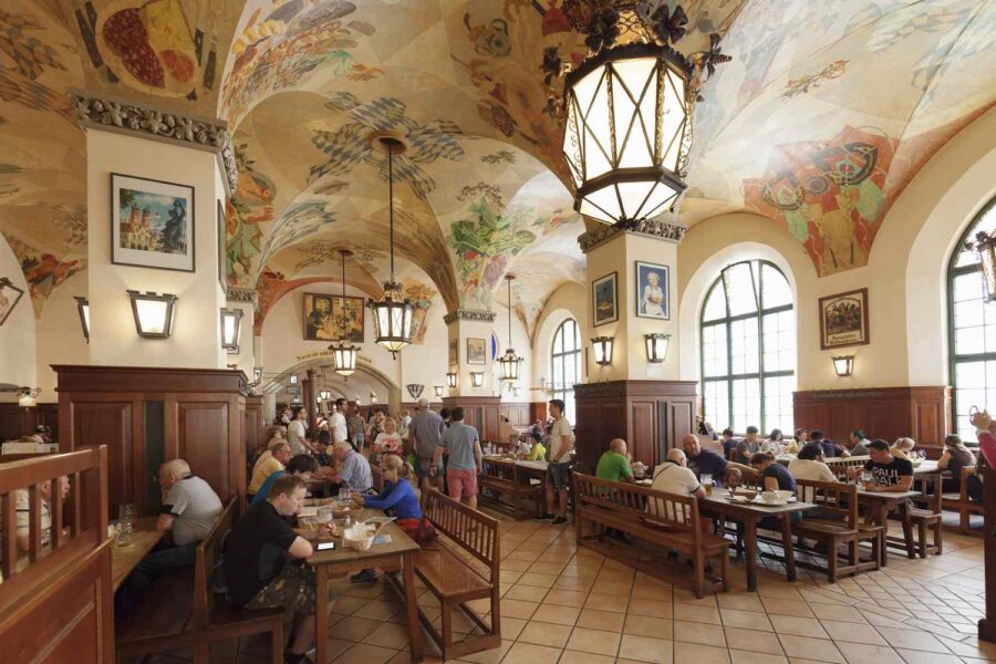 Hofbräuhaus vaulted beer hall in Munich with communal tables and painted ceiling.