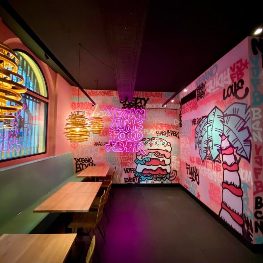 Interior of Vegan Junk Food Bar Amsterdam, with bright, colorful walls adorned with artistic graffiti.