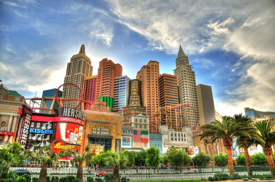 Las Vegas Strip skyline with replicas, roller coaster, palm trees, and iconic Hersheys sign.