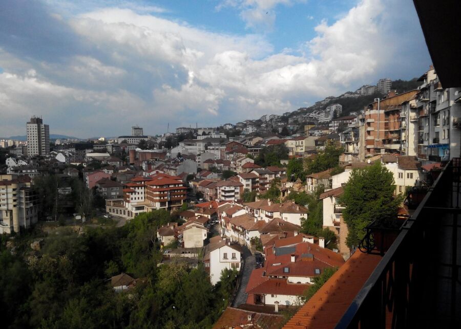 Scenic balcony view of Veliko Tarnovo, highlighting the city's unique architecture and surrounding hills.