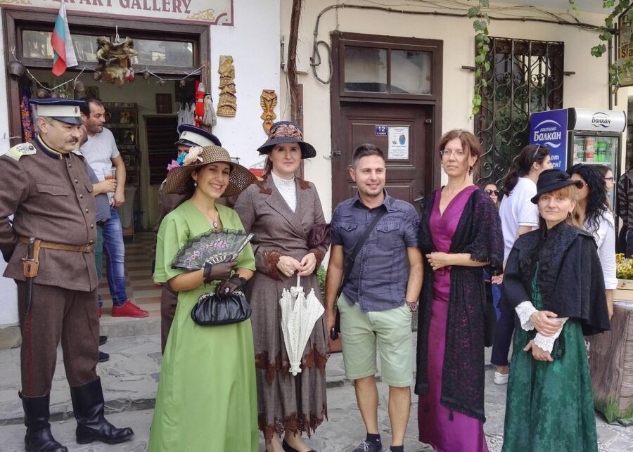 People dressed in period clothing smile for a photo, capturing a moment from the Ultimate Veliko Tarnovo Self-Guided Tour.