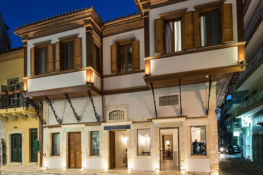 The Veneziano Boutique Hotel features a white facade and wooden windows, showcasing elegant architectural design.