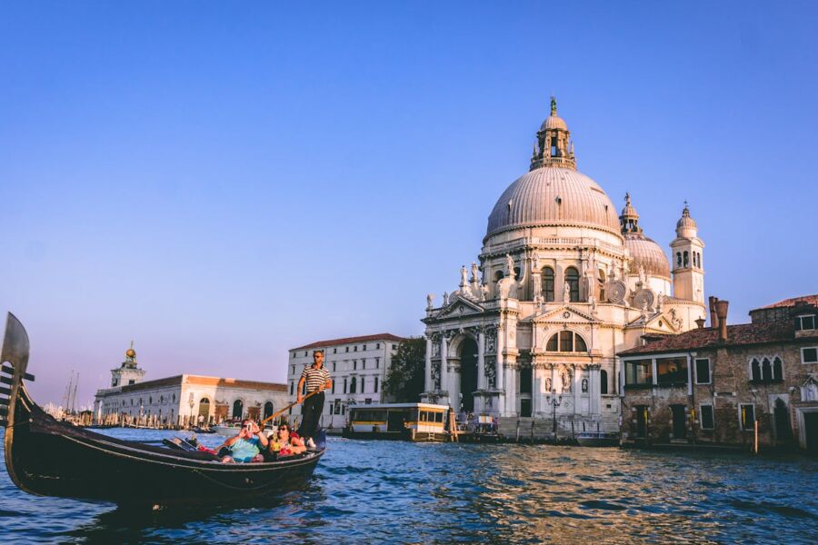 Venice gondola at sunset with Basilica backdrop, showcasing iconic architecture and serene waterways.