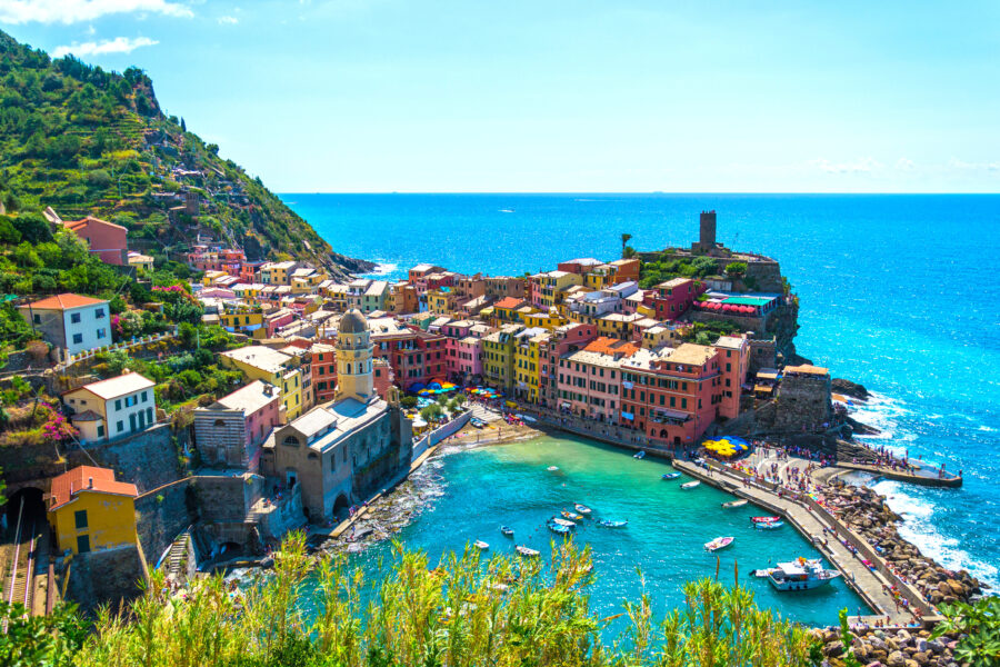 Panoramic view of Vernazza, highlighting its vibrant houses and picturesque harbor along the Cinque Terre coastline